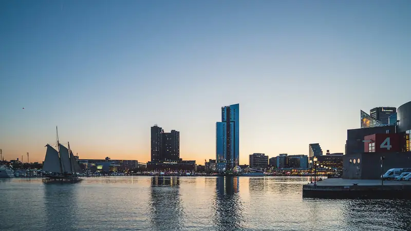 Baltimore's Inner Harbor at sunset, with a tall ship and the skyline