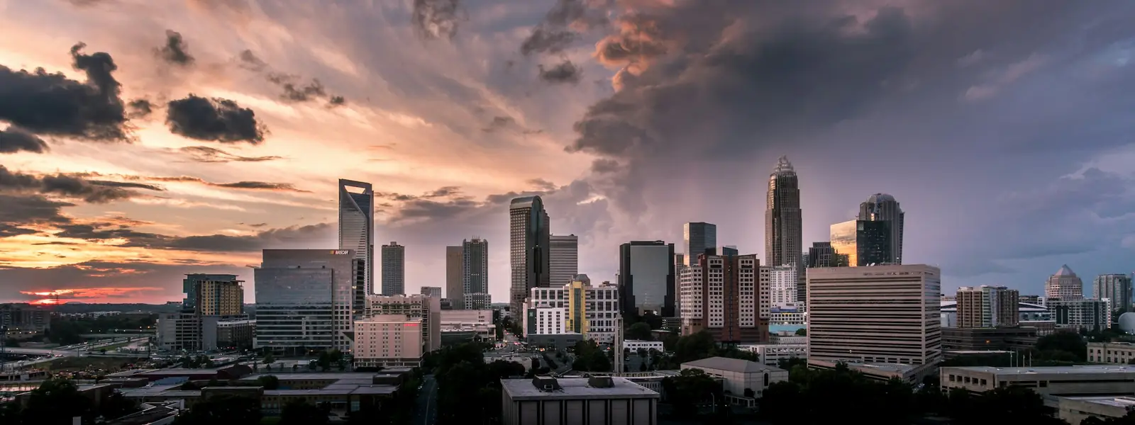 Uptown Charlotte skyline under a stormy sunset sky